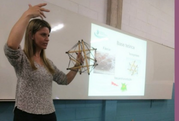 Professora ministrando aula mostrando a lousa - Juliana Botti